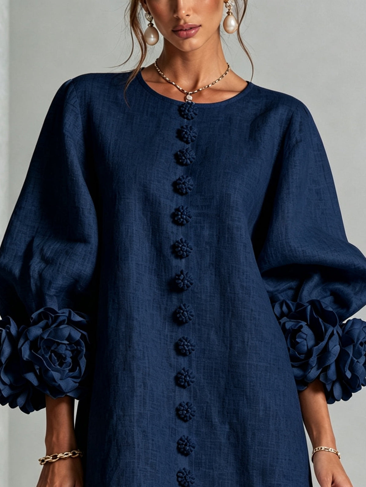Marineblauwe mini-jurk met knoopsluiting en opvallende bloemenmanchetten