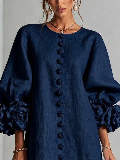 Marineblauwe mini-jurk met knoopsluiting en opvallende bloemenmanchetten