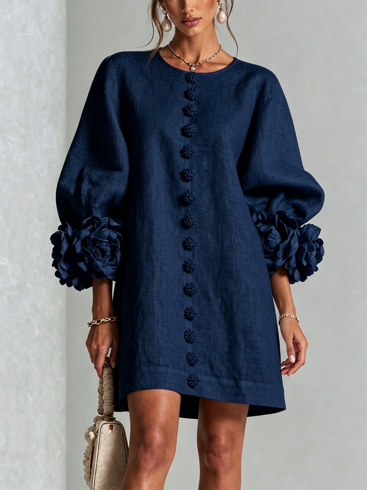 Marineblauwe mini-jurk met knoopsluiting en opvallende bloemenmanchetten
