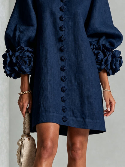 Marineblauwe mini-jurk met knoopsluiting en opvallende bloemenmanchetten