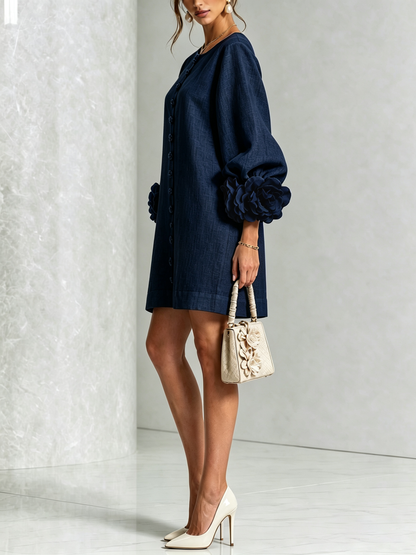 Marineblauwe mini-jurk met knoopsluiting en opvallende bloemenmanchetten